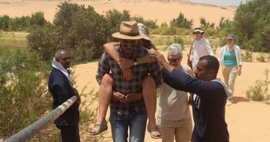 مرشد سياحى يحمل سائحة على ظهره 300 متر بعد إصابتها بضربة شمس فى أسوان.. صور